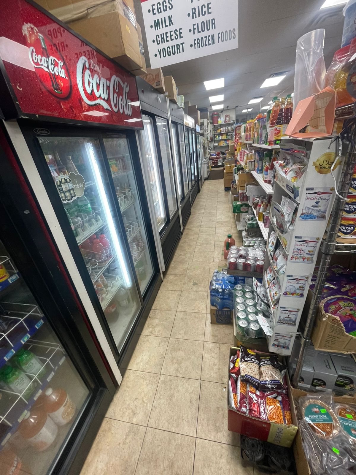 Refrigerated coolers stocked with milk, yogurt, cheese, eggs and beverages at Al-Khair Halal Grocery