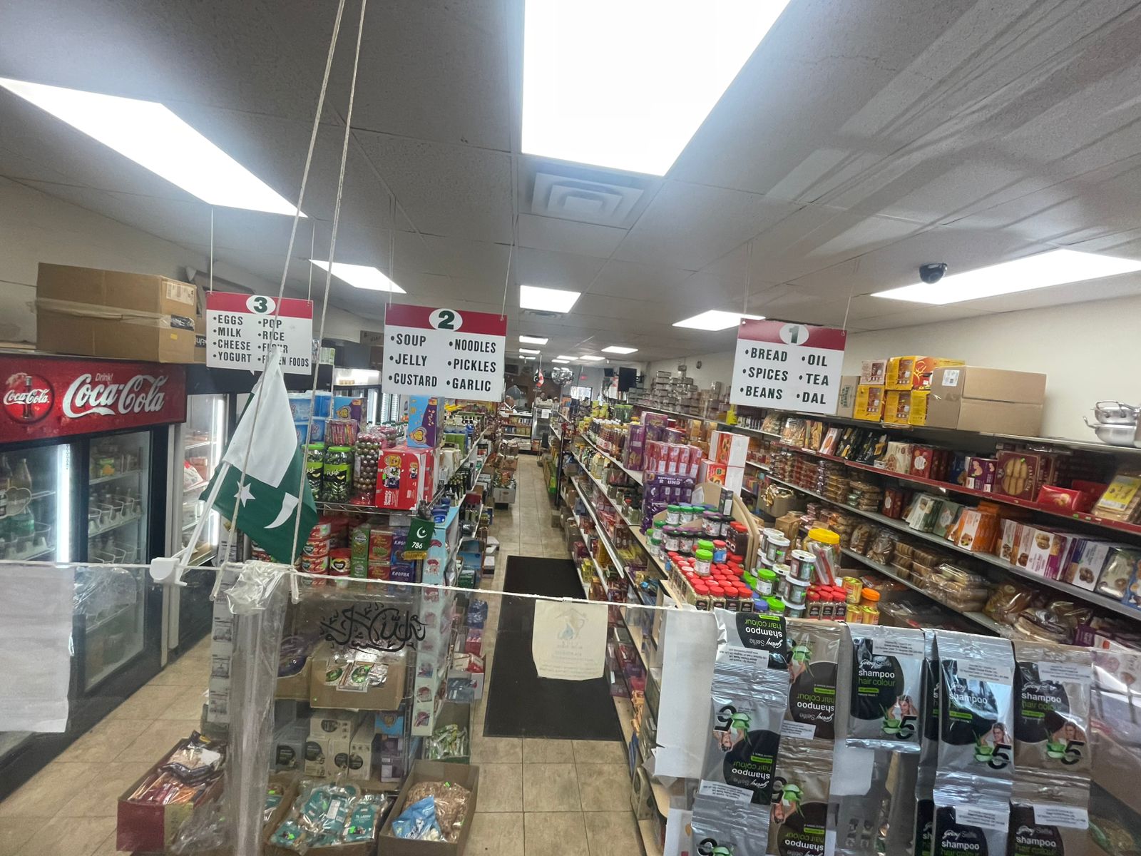 Inside Al-Khair Halal Grocery Mississauga showing labeled aisles for bread, oil, spices, tea, rice and dal